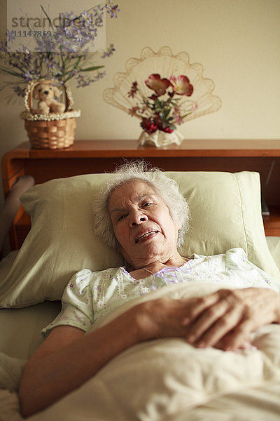 Ältere Frau gemischter Rasse liegt im Bett