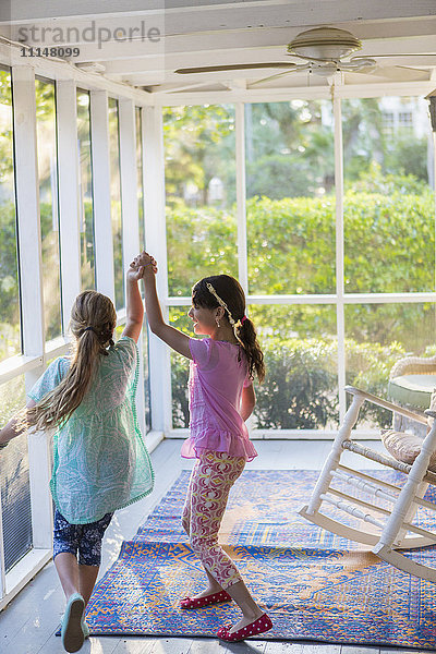 Mädchen spielen zusammen auf der Veranda