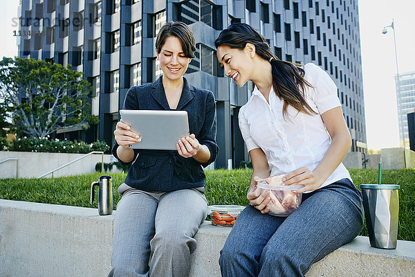 Geschäftsfrauen benutzen Tablet-Computer in der Stadt