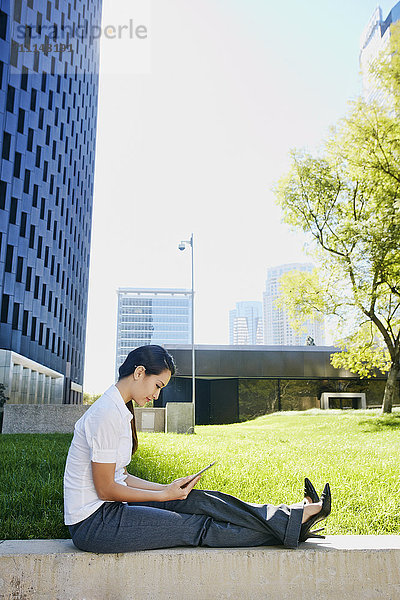 Gemischtrassige Geschäftsfrau mit Tablet-Computer in der Stadt