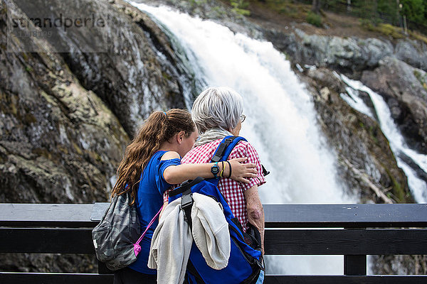 Großmutter und Enkelin bewundern Wasserfall