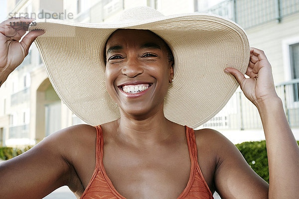 Schwarze Frau mit Sonnenhut im Freien