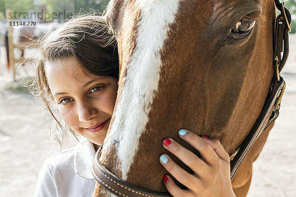 Nahaufnahme eines jugendlichen Mädchens  das ein Pferd umarmt