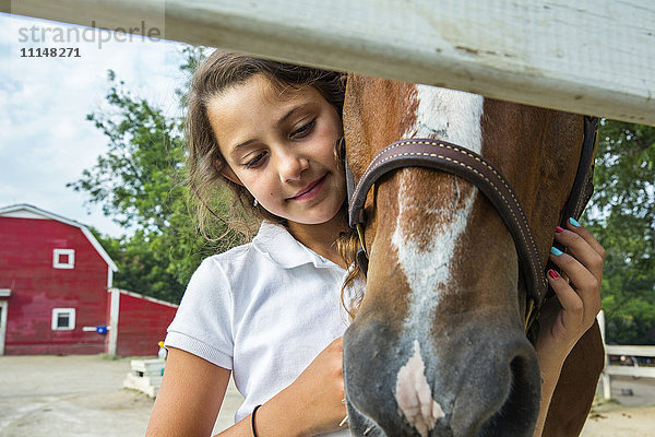 Nahaufnahme eines jugendlichen Mädchens  das ein Pferd auf einer Ranch umarmt