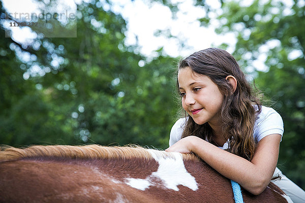 Nahaufnahme eines jugendlichen Mädchens auf einem Pferd