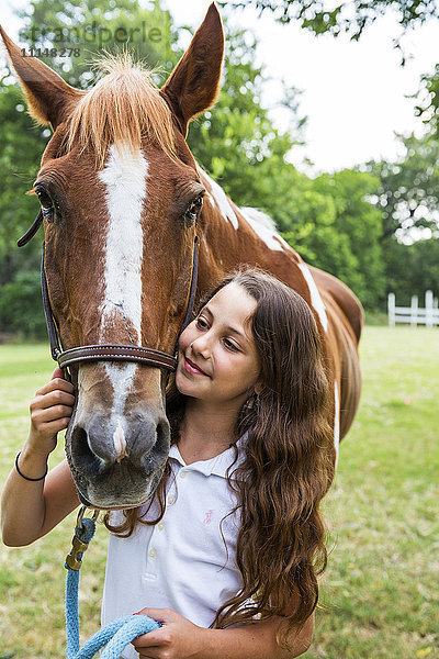 Teenager-Mädchen führt Pferd im Feld