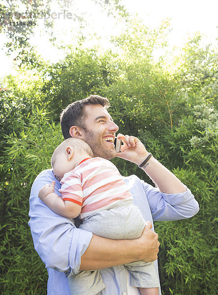 Kaukasischer Vater hält Baby am Handy