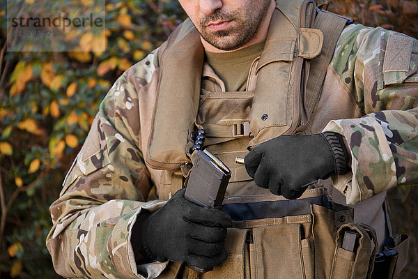 Soldat beim Laden einer automatischen Waffe während der Ausbildung