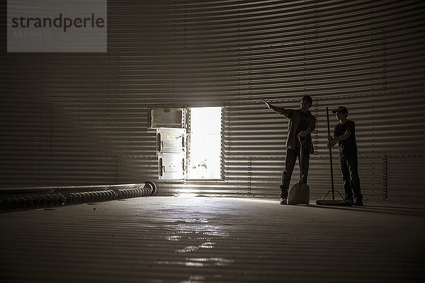 Kaukasischer Vater und seine Tochter stehen in einem leeren Silo