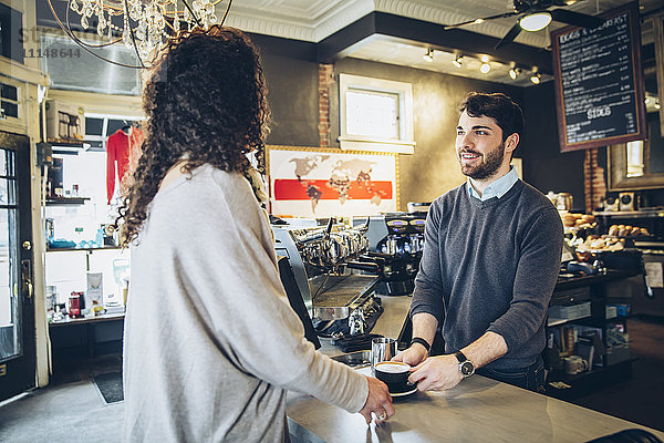 Barista serviert Kunden Kaffee im Café