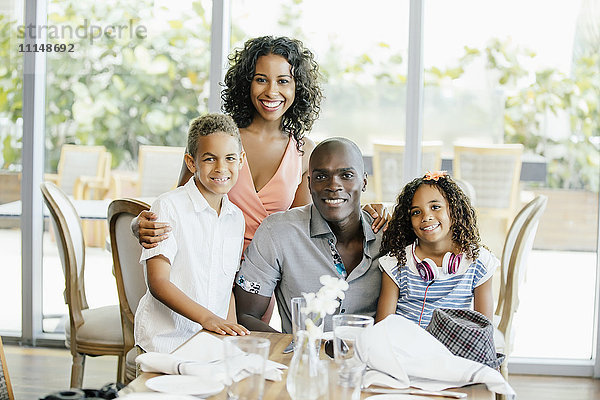 Familie lächelnd am Restauranttisch