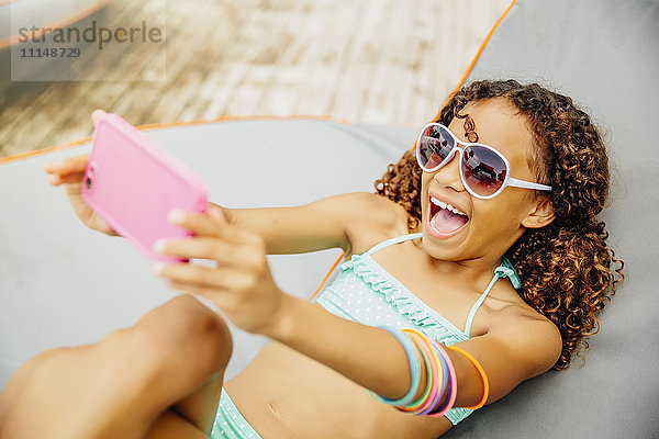 Gemischte Rasse Mädchen nehmen Selfie mit Handy auf der Terrasse