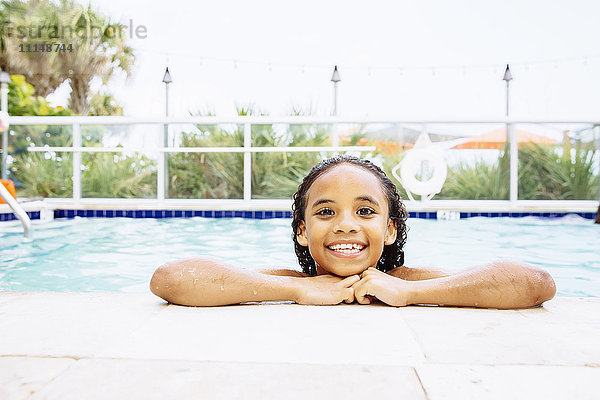 Gemischtrassiges Mädchen lächelnd im Schwimmbad