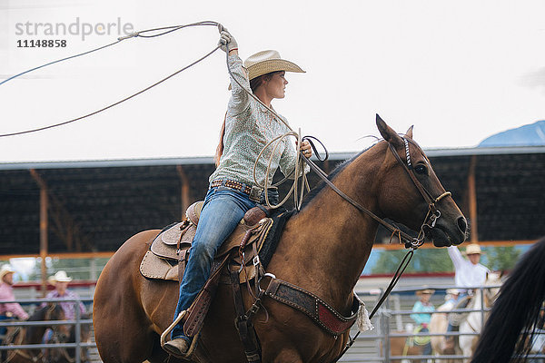 Kaukasisches Cowgirl wirbelt Lasso beim Rodeo