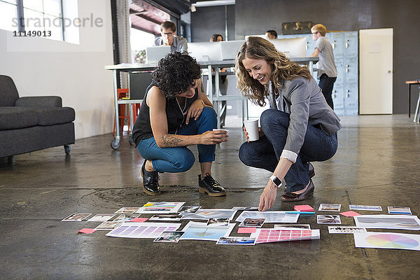 Geschäftsfrauen prüfen Papierkram auf dem Büroboden