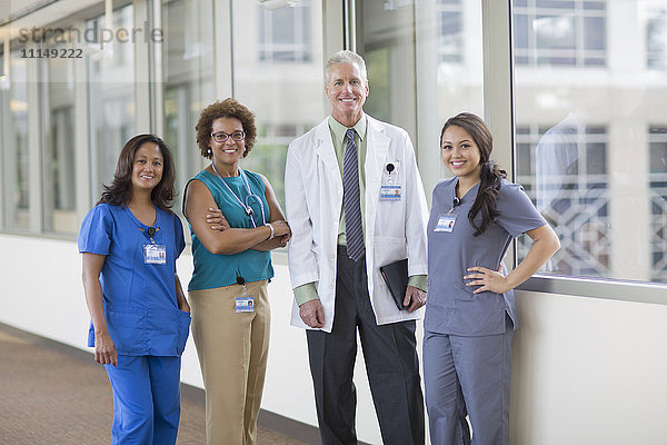 Arzt und Krankenschwestern lächelnd im Krankenhausflur