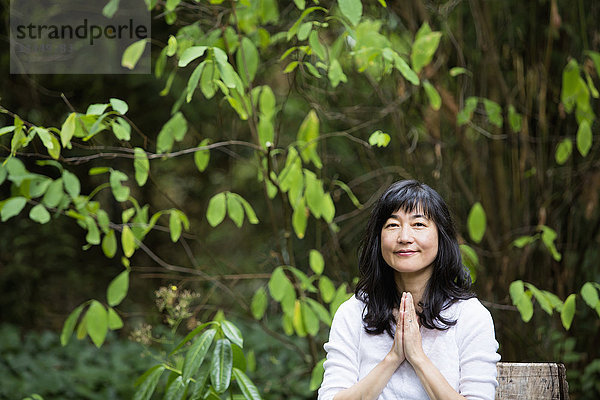 Japanische Frau meditiert im Garten