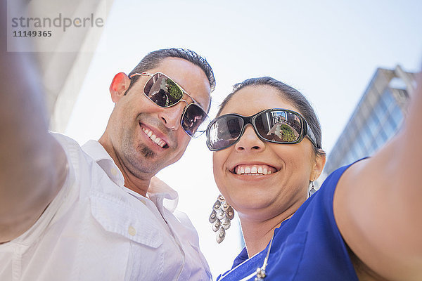 Niedriger Blickwinkel auf ein hispanisches Paar mit Sonnenbrille