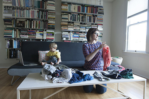 Mutter und Sohn falten Wäsche