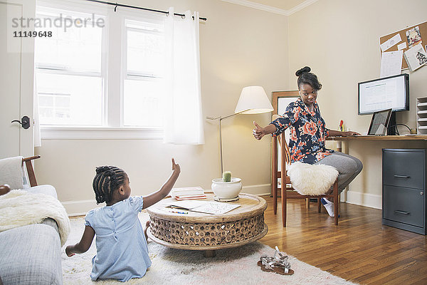 Afroamerikanische Mutter und Tochter gestikulieren mit dem Daumen nach oben