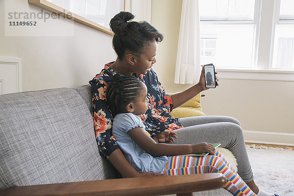 Afroamerikanische Mutter und Tochter beim Videochat mit dem Handy