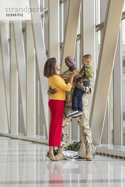 Afroamerikanischer Soldat begrüßt Familie am Flughafen