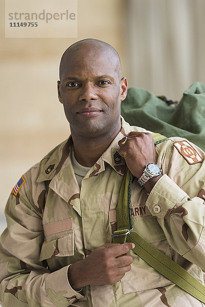 Afroamerikanischer Soldat trägt Seesack