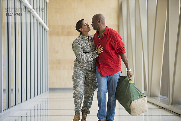 Afroamerikanischer Soldat im Gespräch mit Ehemann am Flughafen