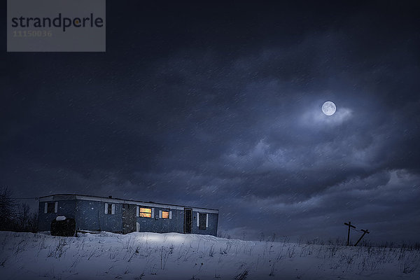 Mond über Wohnwagen Haus in verschneiten Hof