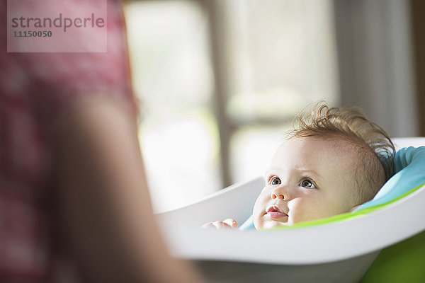 Kaukasisches kleines Mädchen in der Badewanne liegend