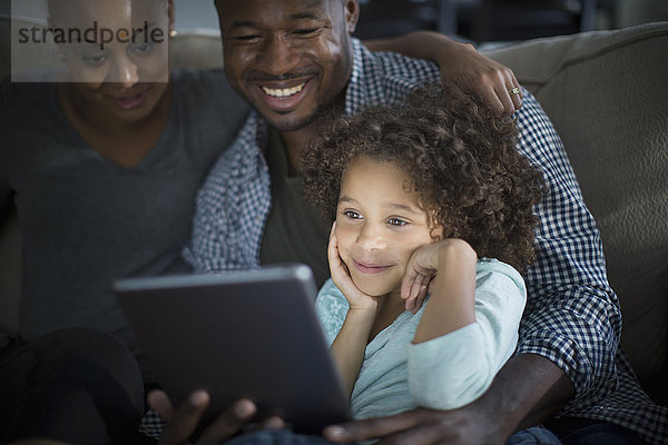Familie benutzt digitales Tablet auf dem Sofa
