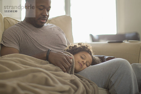 Vater und Tochter kuscheln auf dem Sofa