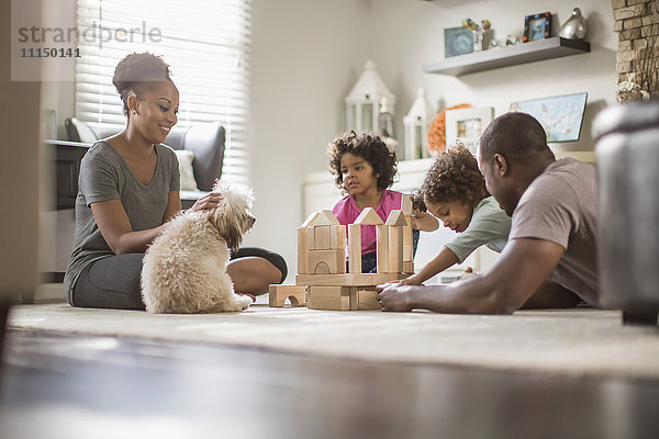 Familie spielt mit Bauklötzen im Wohnzimmer