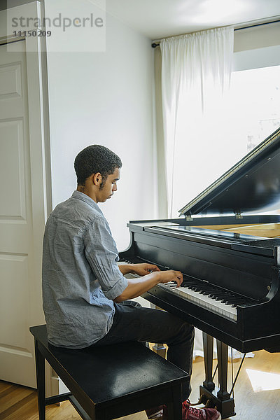 Gemischtrassiger Junge spielt Klavier