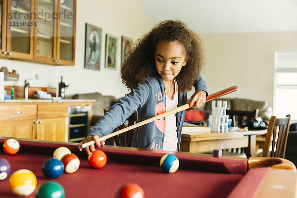 Gemischtrassiges Mädchen spielt Pool