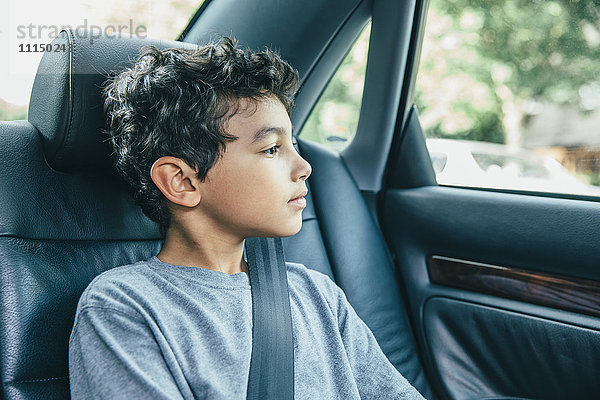 Gemischtrassiger Junge auf dem Rücksitz eines Autos