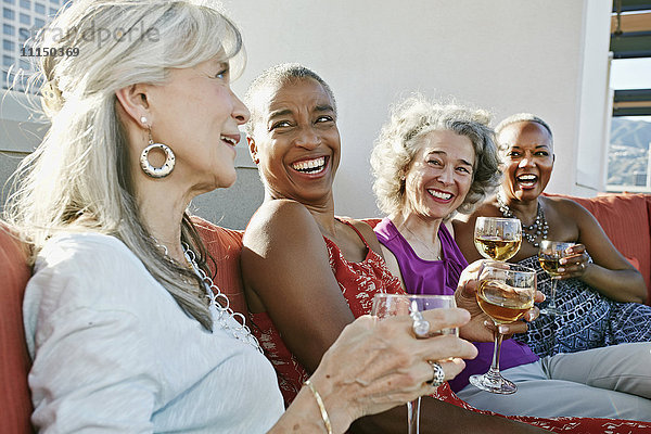 Frauen trinken gemeinsam Wein auf einem städtischen Dach