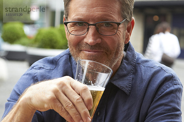 Kaukasischer Mann trinkt Bier im Freien