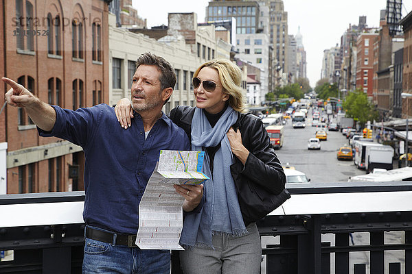 Kaukasisches Paar hält Karte in der Stadt  New York City  New York  Vereinigte Staaten
