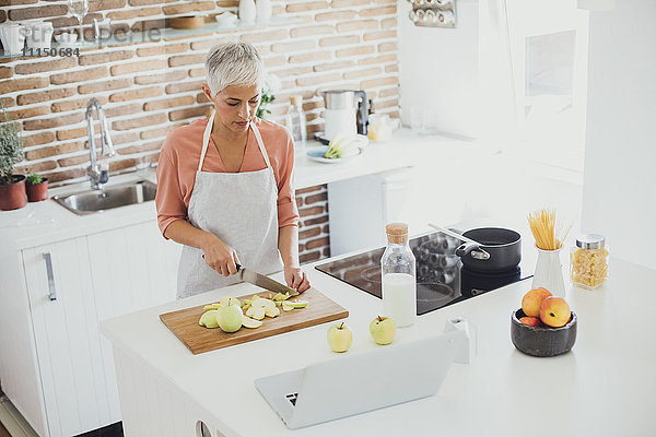 Ältere kaukasische Frau schneidet Äpfel in der Küche