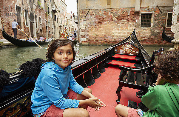 Junge sitzt in einer Gondel auf dem Kanal von Venedig  Venetien  Italien