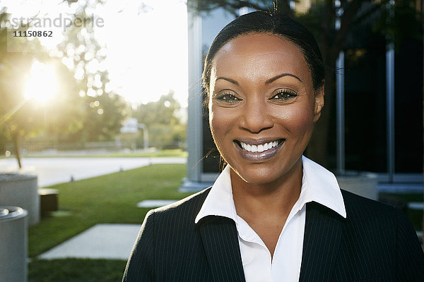 Schwarze Geschäftsfrau lächelnd im Freien
