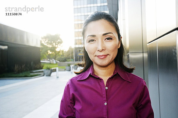 Asiatische Geschäftsfrau lächelnd im Freien
