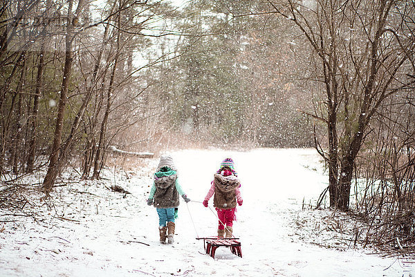 Mädchen gehen in verschneitem Feld