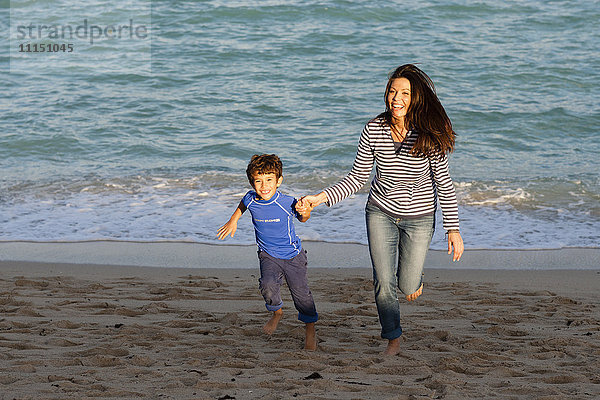 Kaukasische Mutter und Sohn spielen am Strand