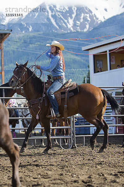 Kaukasisches Cowgirl reitet auf einem Pferd beim Rodeo auf einer Ranch