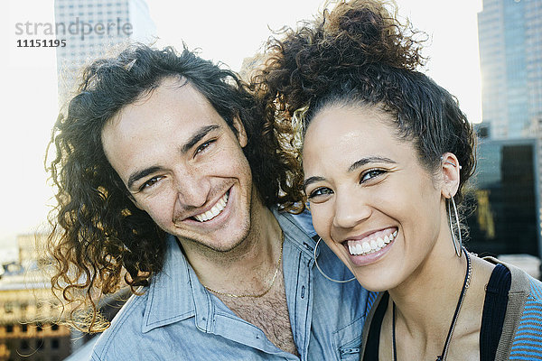 Lächelndes Paar auf dem Dach einer Stadt