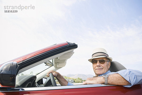 Älterer kaukasischer Mann fährt Cabrio