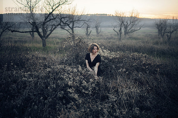 Kaukasische Frau sitzt in einem abgelegenen Feld