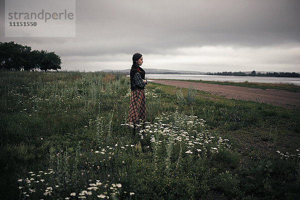 Kaukasische Frau steht in einem abgelegenen Feld